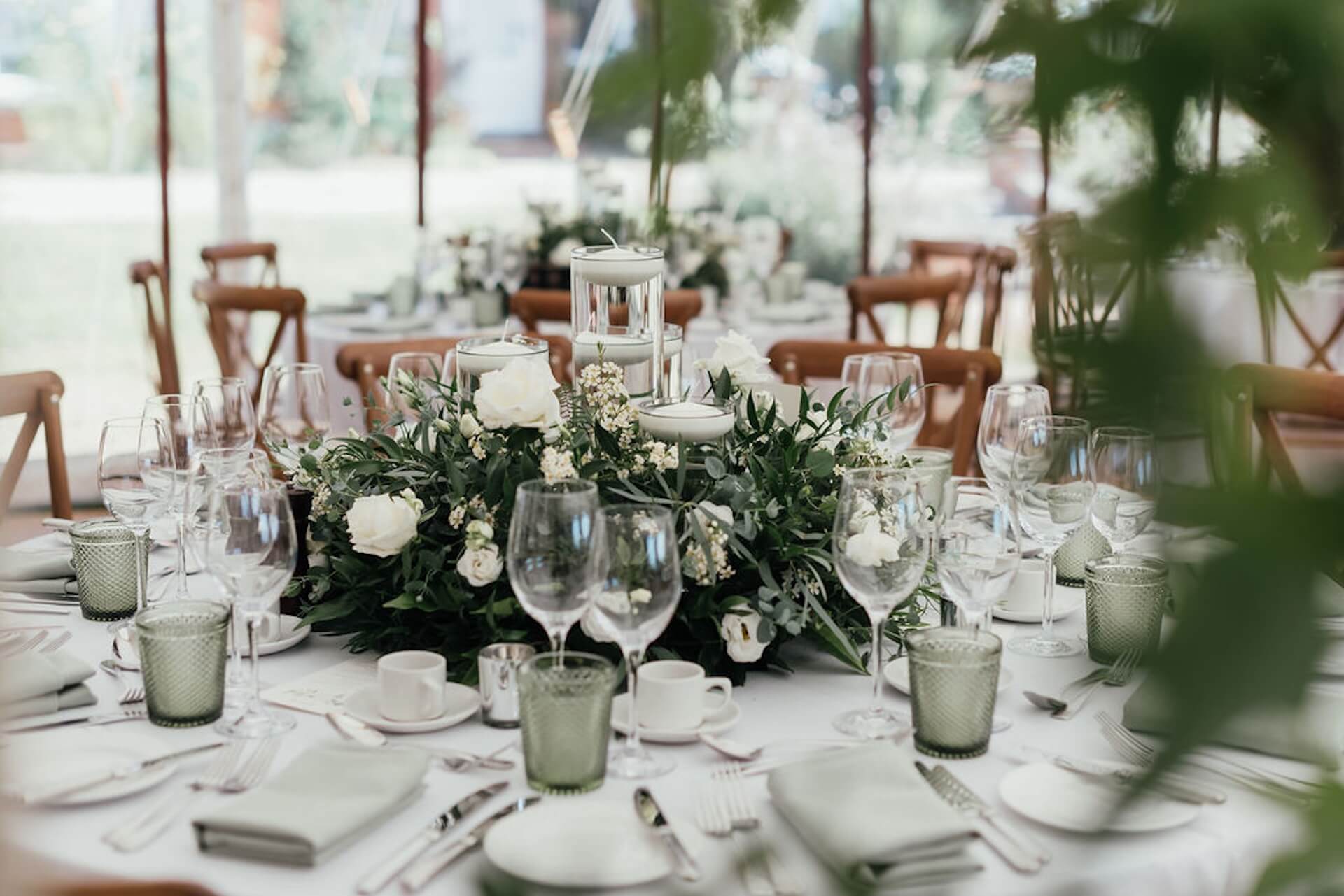 Elegant English marquee wedding table with white flowers, greenery and candlelight